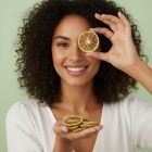 beautiful female model holding dehydrated lime wheel while smiling
